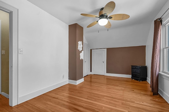 additional living space with vaulted ceiling, baseboards, and light wood-type flooring