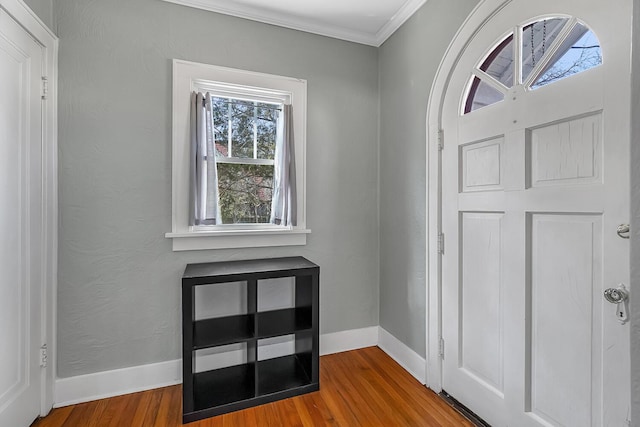 foyer entrance with baseboards, wood finished floors, and crown molding