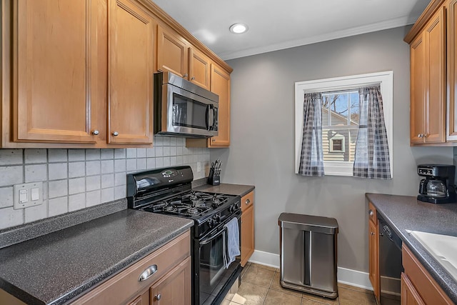 kitchen with dark countertops, backsplash, baseboards, ornamental molding, and black appliances