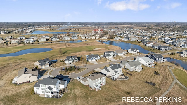 drone / aerial view with a residential view, view of golf course, and a water view