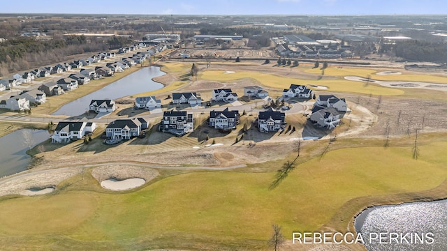 drone / aerial view featuring golf course view, a water view, and a residential view