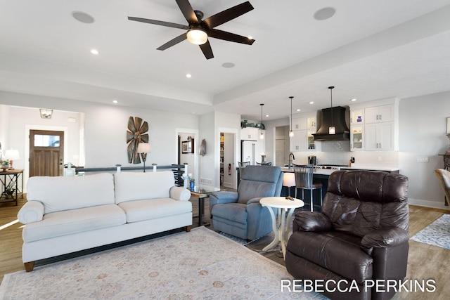 living area featuring a ceiling fan, light wood-style flooring, recessed lighting, and baseboards