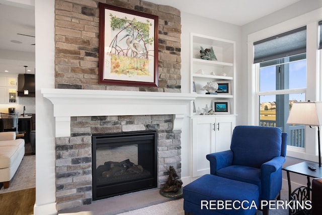 sitting room featuring built in features and a fireplace