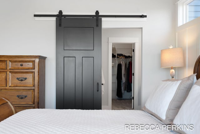 bedroom with a walk in closet, a barn door, and a closet