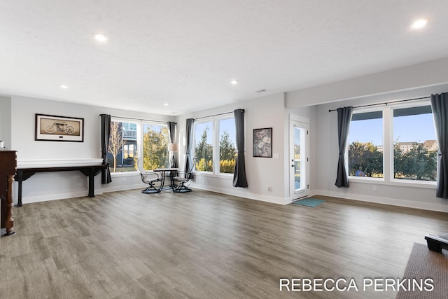 unfurnished living room with recessed lighting, baseboards, and wood finished floors