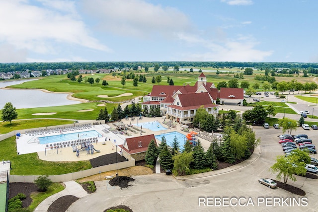 drone / aerial view with a water view and view of golf course