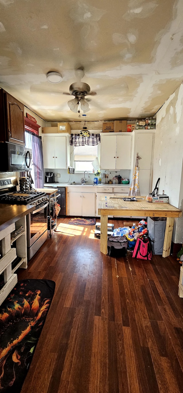 kitchen featuring black appliances, light countertops, dark wood-style floors, white cabinetry, and a sink