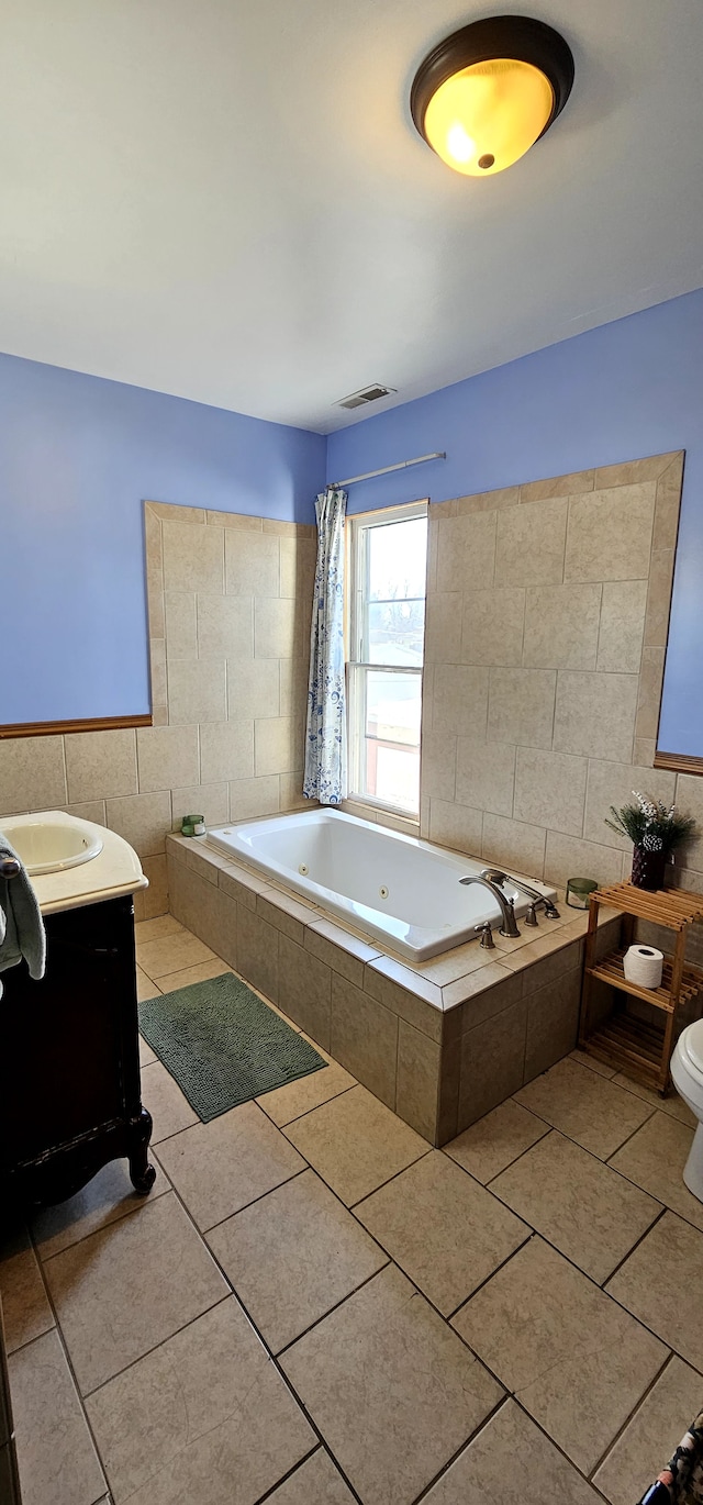 full bath with toilet, a shower with shower curtain, tile patterned floors, a tub with jets, and tile walls