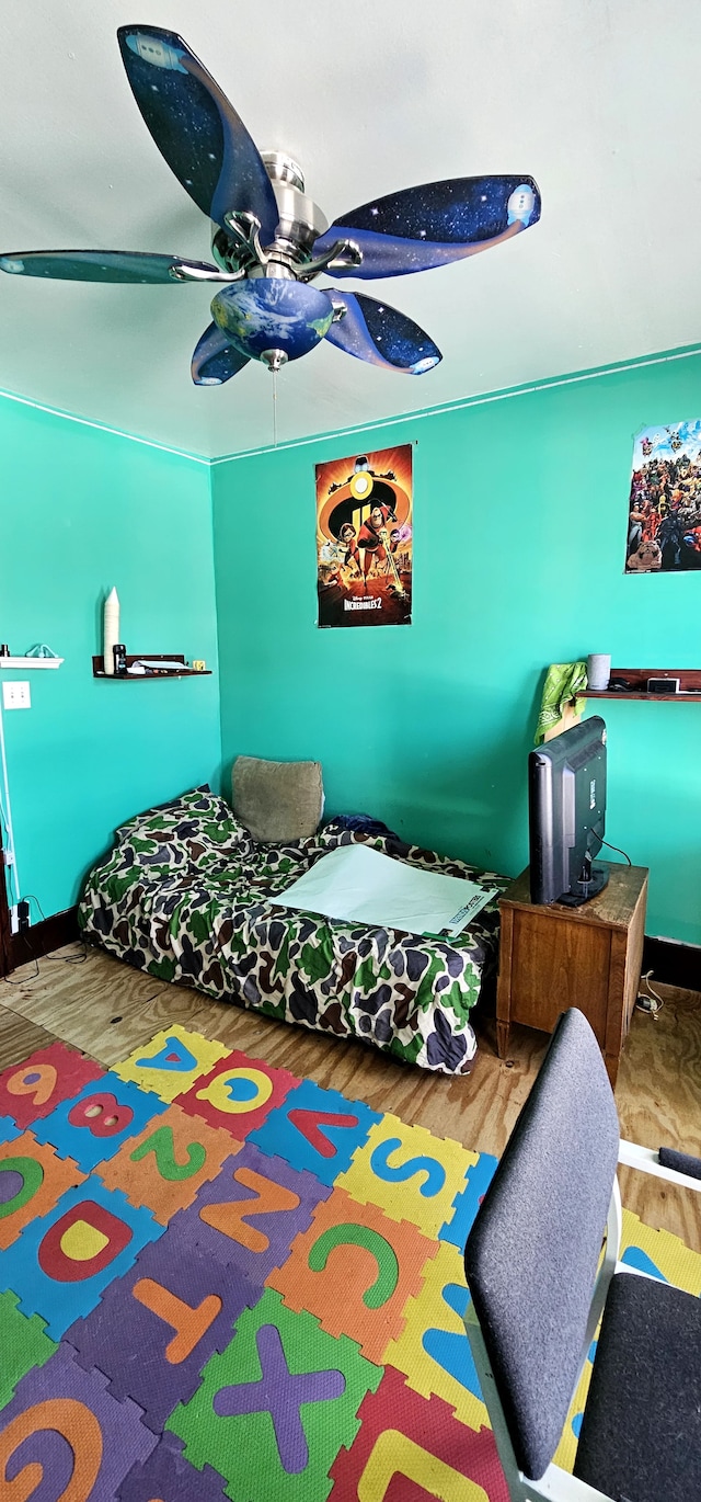 bedroom with a ceiling fan, wood finished floors, and baseboards