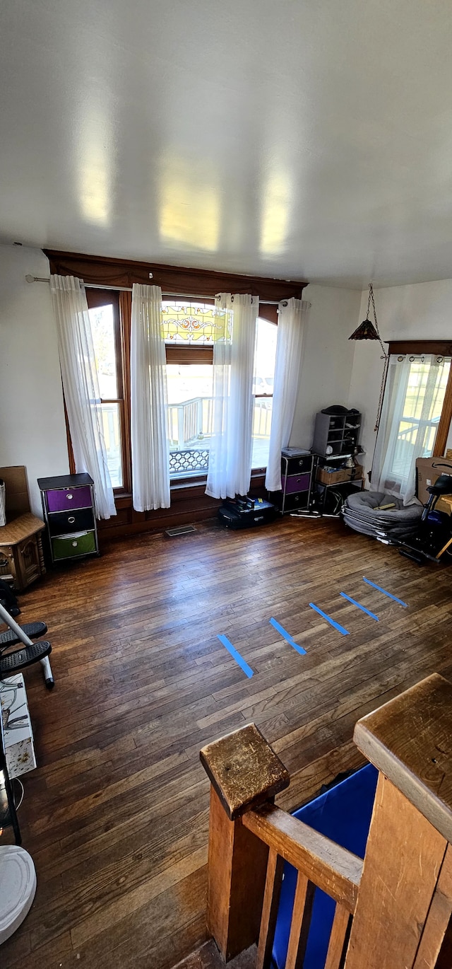 unfurnished living room with visible vents and dark wood finished floors