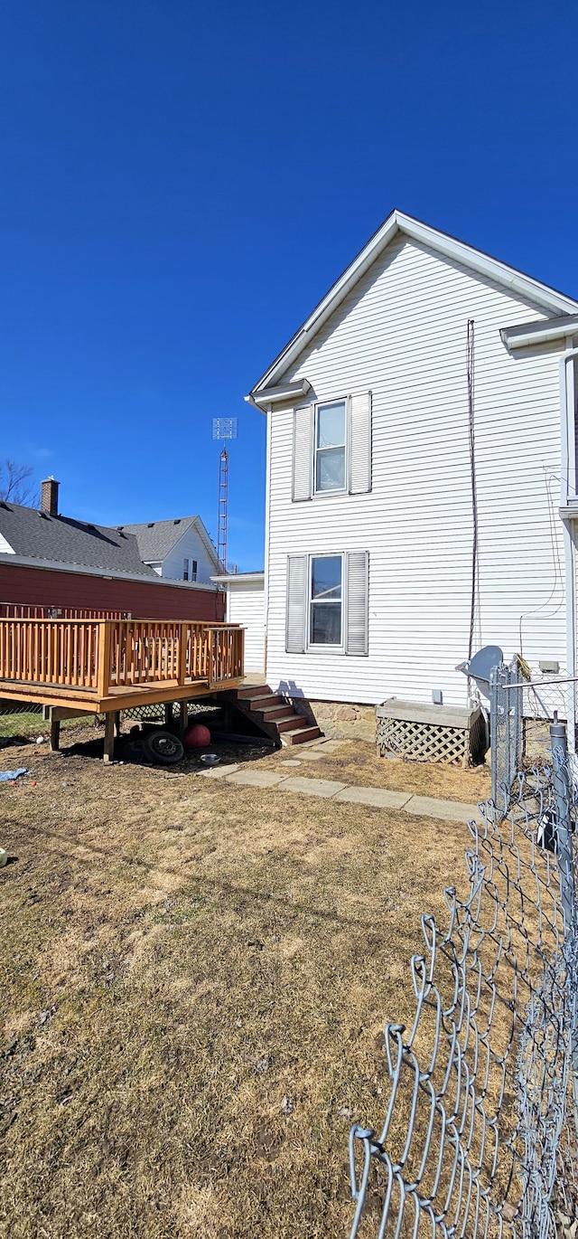 rear view of house with a yard and a deck