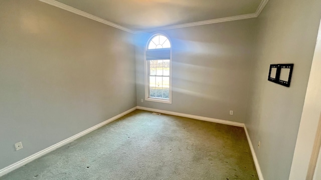 spare room featuring carpet flooring, baseboards, visible vents, and crown molding