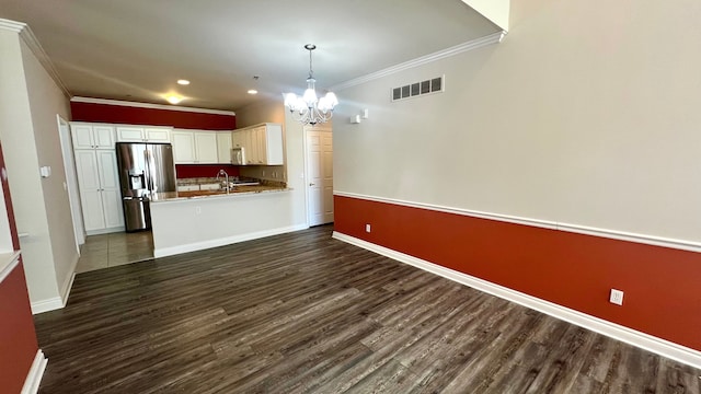 kitchen featuring visible vents, an inviting chandelier, dark wood-type flooring, white cabinets, and stainless steel fridge