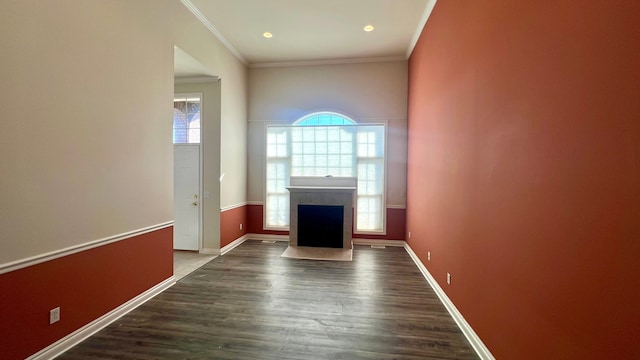 unfurnished living room featuring baseboards, dark wood-style floors, a fireplace, and ornamental molding