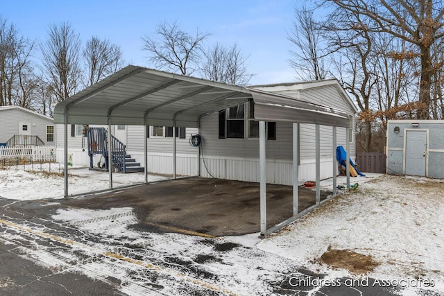 snow covered parking featuring a carport