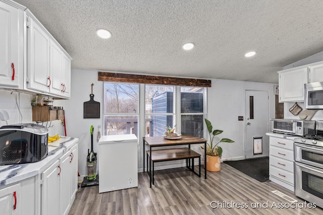 kitchen featuring light wood finished floors, appliances with stainless steel finishes, light countertops, and white cabinetry