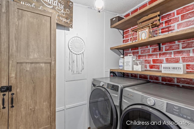 laundry room featuring laundry area, washing machine and dryer, and a textured ceiling