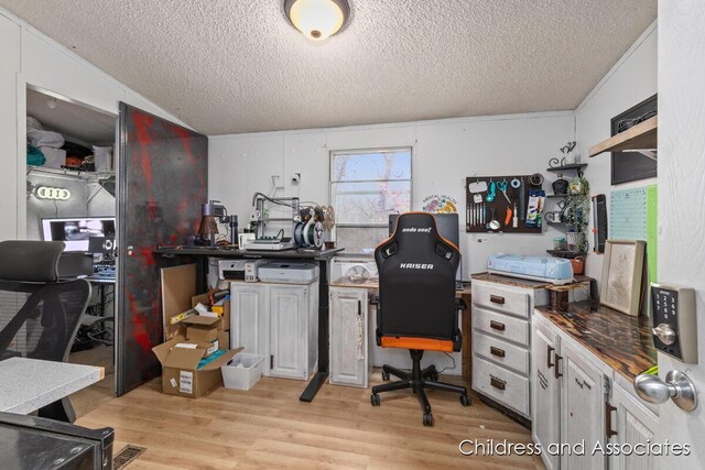 office area with light wood finished floors and a textured ceiling