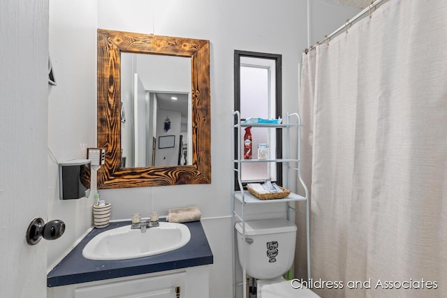 bathroom featuring vanity, curtained shower, and toilet