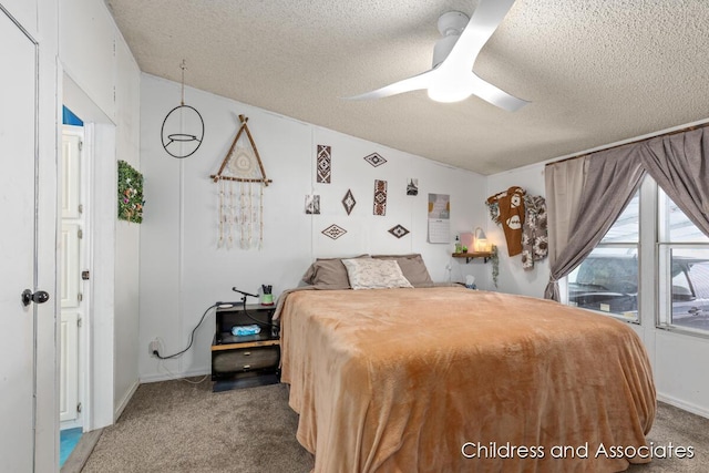 carpeted bedroom featuring a textured ceiling and a ceiling fan