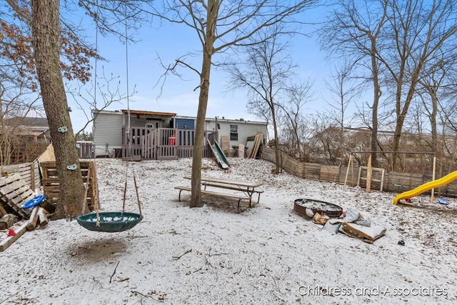 exterior space with fence, a deck, and a playground