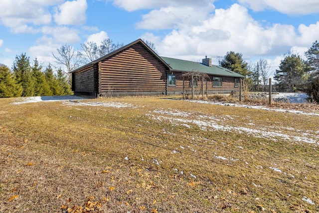 exterior space featuring log siding and a chimney