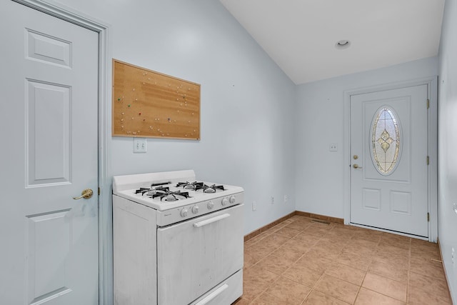 entrance foyer featuring lofted ceiling, light tile patterned floors, and baseboards