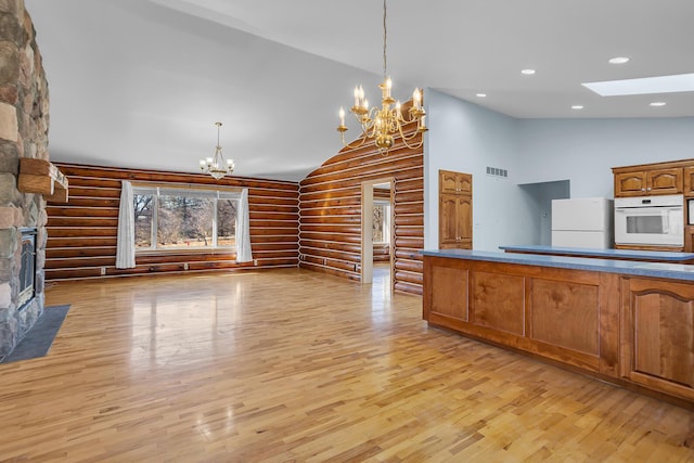 kitchen featuring a chandelier, recessed lighting, a fireplace, white appliances, and high vaulted ceiling