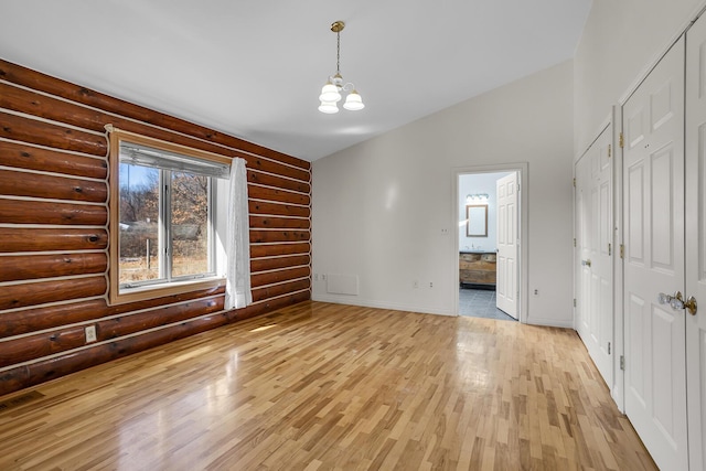 unfurnished dining area with visible vents, light wood-style flooring, baseboards, a chandelier, and vaulted ceiling