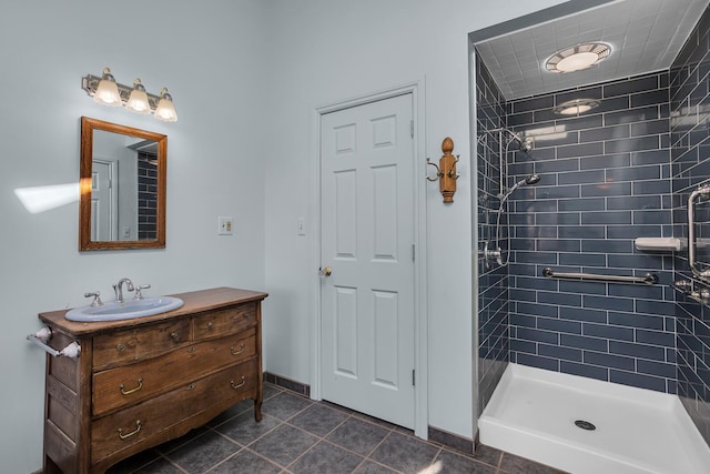 full bath with a stall shower, vanity, and baseboards