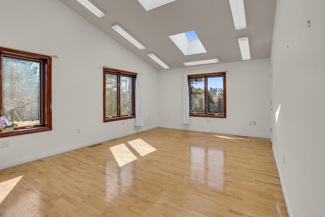 unfurnished room featuring light wood-style flooring, visible vents, baseboards, and high vaulted ceiling