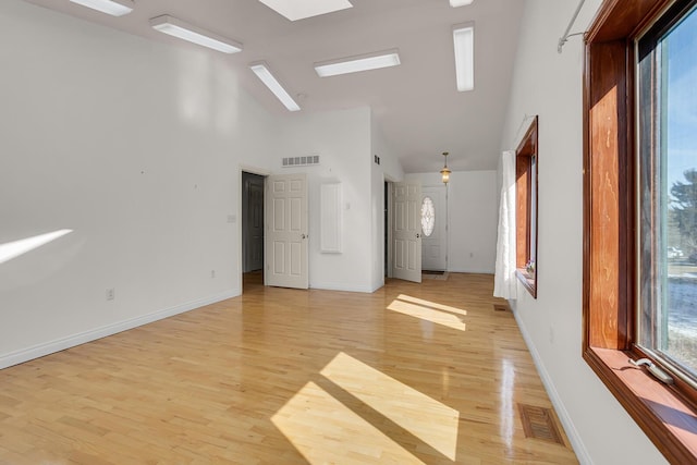 spare room featuring light wood-style flooring, visible vents, and a wealth of natural light