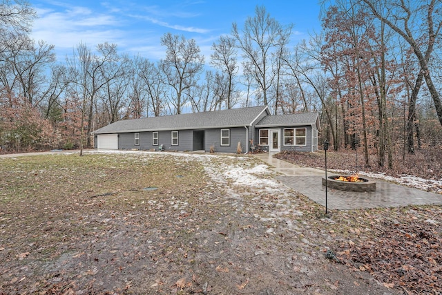 view of front facade featuring an outdoor fire pit and a garage