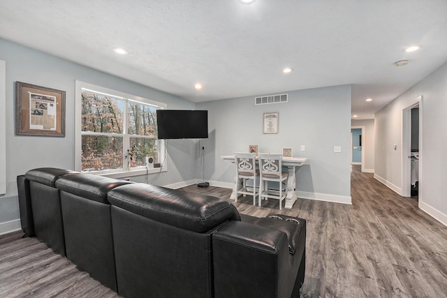 living area featuring wood finished floors, baseboards, and recessed lighting
