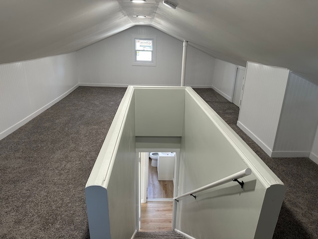 staircase with vaulted ceiling and carpet