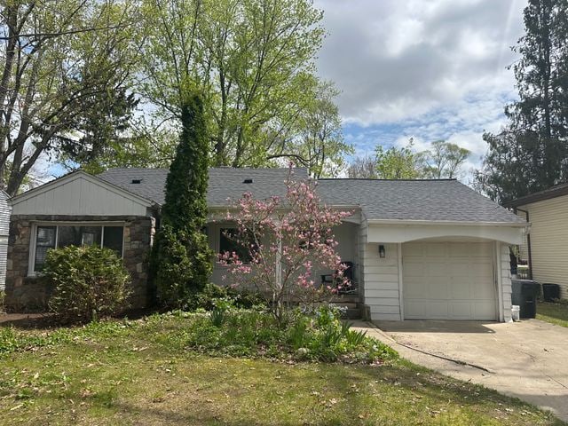 4120 Lotus Dr, Waterford, MI 48329 - ranch-style house with driveway, a garage, stone siding, and a shingled roof