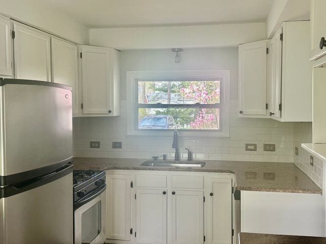 4120 Lotus Dr, Waterford, MI 48329 - kitchen with stainless steel appliances, white cabinets, and tasteful backsplash