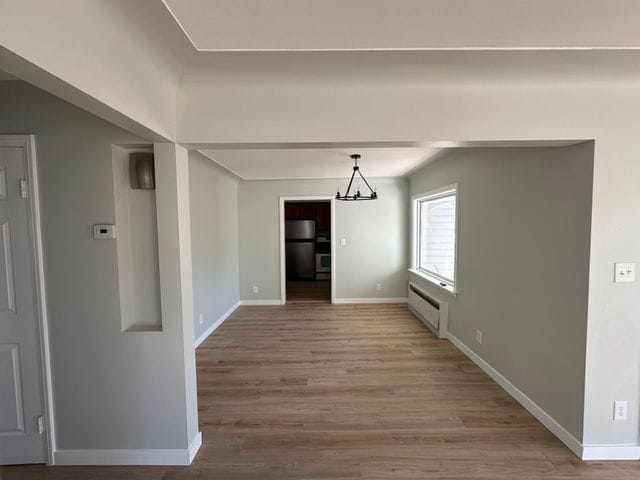 4120 Lotus Dr, Waterford, MI 48329 - unfurnished dining area featuring wood finished floors and a chandelier