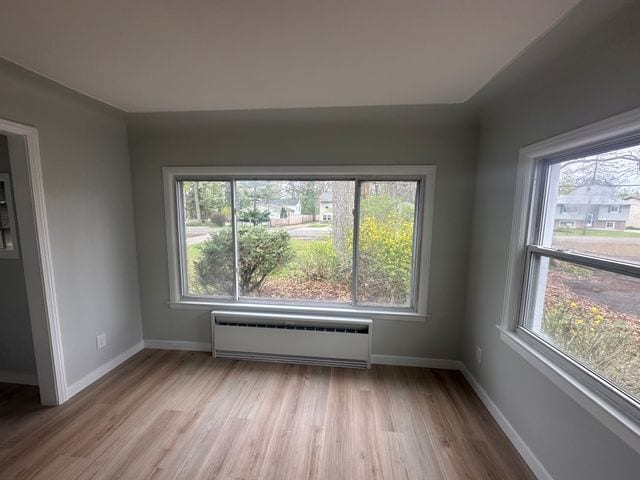4120 Lotus Dr, Waterford, MI 48329 - unfurnished room with radiator heating unit, plenty of natural light, and wood finished floors