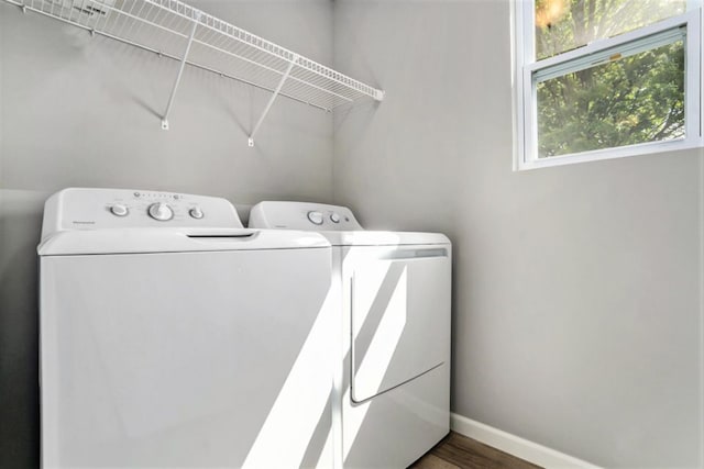 laundry area with baseboards, wood finished floors, laundry area, and washing machine and clothes dryer