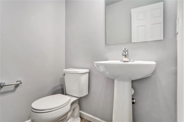 bathroom featuring toilet and baseboards