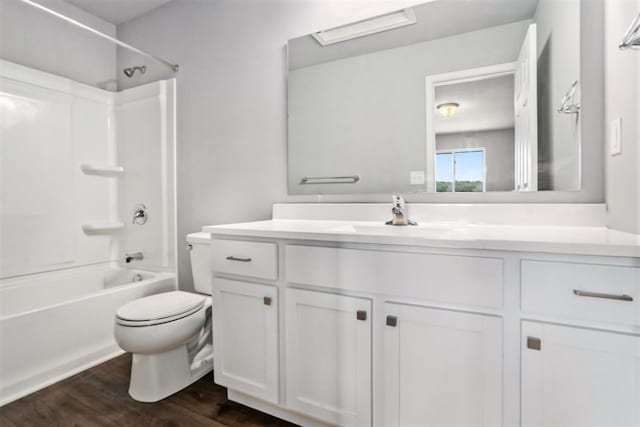 bathroom with vanity, toilet, wood finished floors, and bathtub / shower combination