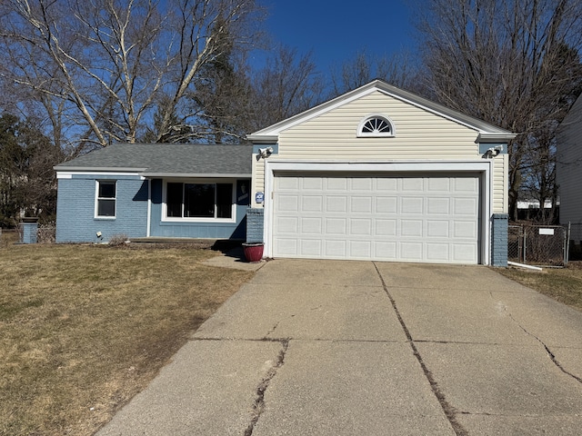 single story home featuring brick siding, fence, a front yard, a garage, and driveway