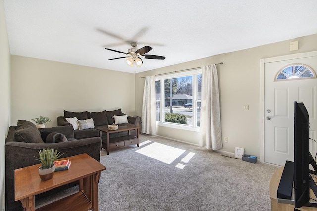 carpeted living room featuring baseboards and ceiling fan