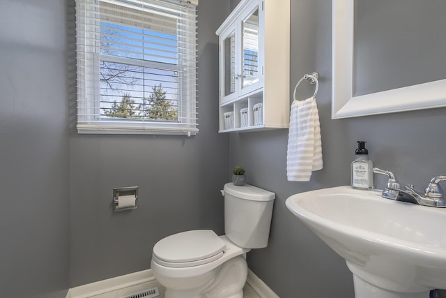 bathroom with a sink, baseboards, and toilet