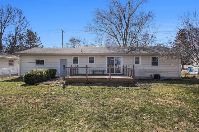 rear view of property featuring central air condition unit, a lawn, a wooden deck, and fence