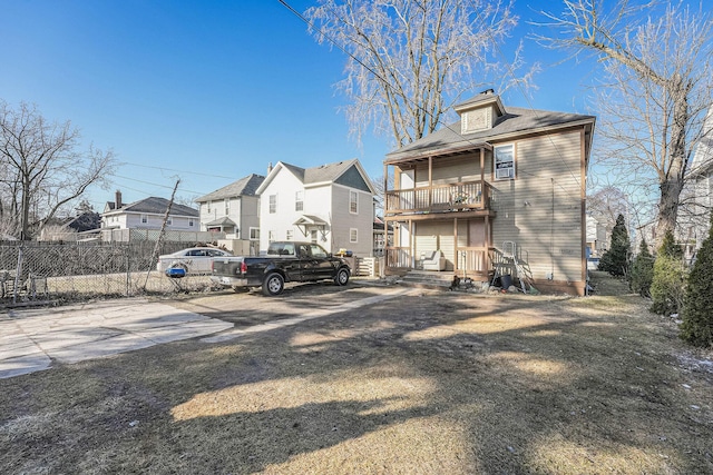 rear view of property featuring fence and a residential view