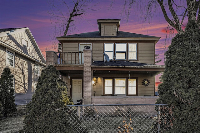 view of front of property featuring a balcony and fence