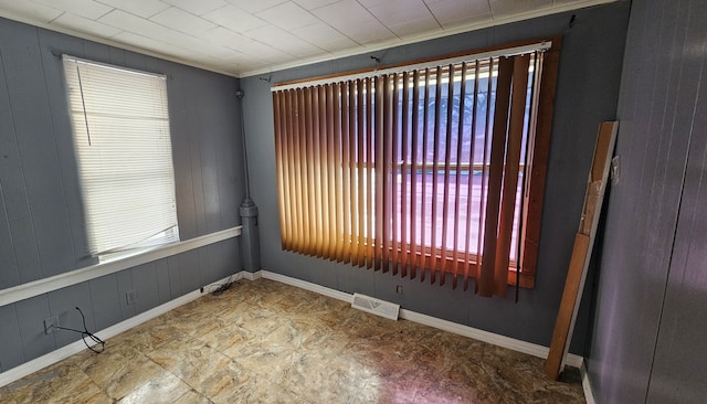 unfurnished room featuring plenty of natural light, baseboards, and visible vents