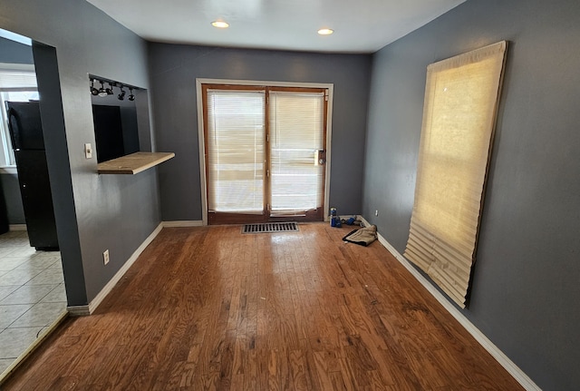 spare room featuring recessed lighting, wood finished floors, and baseboards